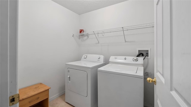 laundry area featuring washer and clothes dryer and light tile patterned floors