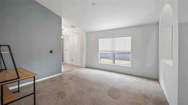 carpeted spare room featuring a textured ceiling