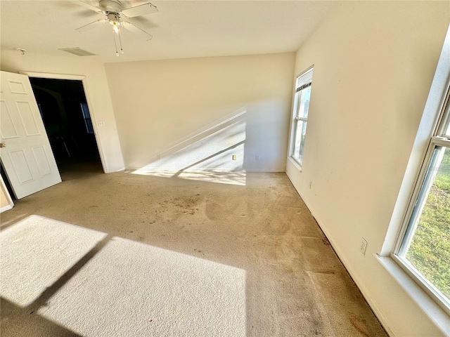 spare room with ceiling fan and light carpet