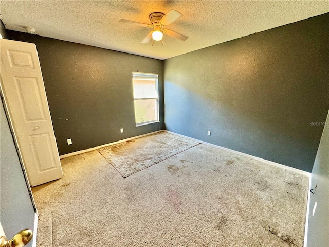 carpeted empty room featuring a textured ceiling and ceiling fan