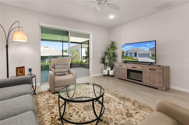 living room with ceiling fan and light hardwood / wood-style flooring