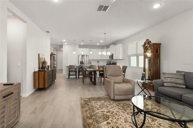 living room featuring a chandelier and a textured ceiling