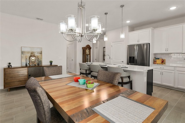 dining space with sink and a notable chandelier