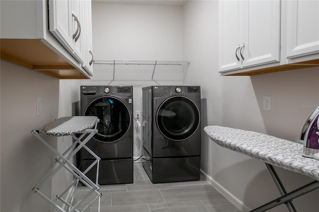 laundry area with washing machine and clothes dryer and cabinets