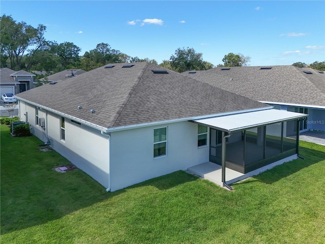 rear view of house with a yard, a sunroom, and a patio area