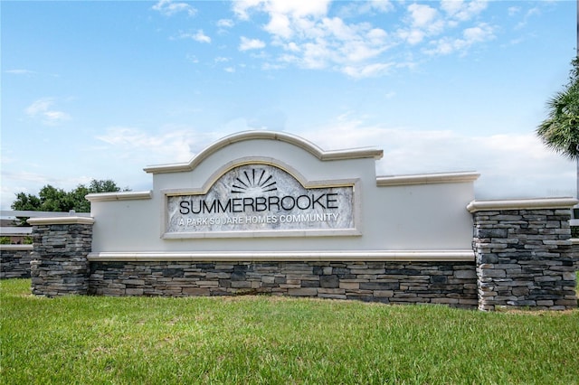 community / neighborhood sign featuring a yard