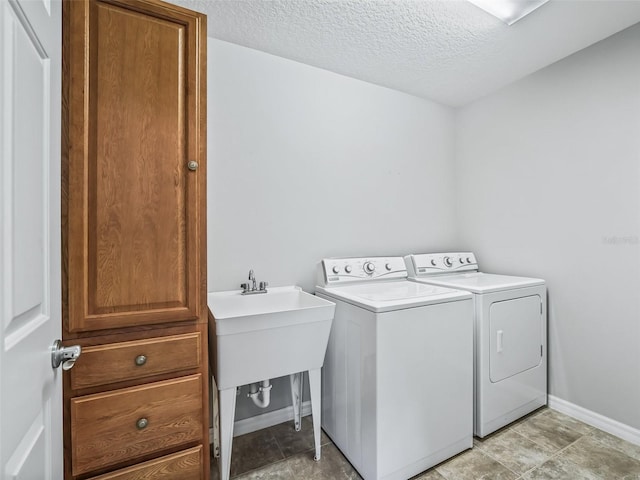 washroom with washer and dryer and a textured ceiling