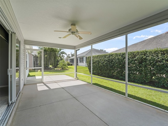 unfurnished sunroom featuring ceiling fan