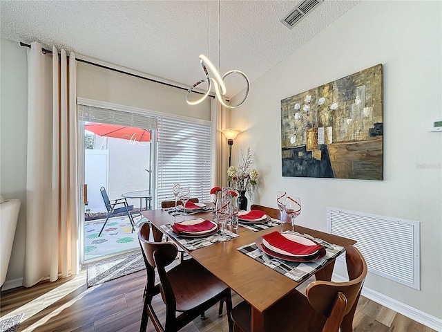 dining area with hardwood / wood-style flooring, a textured ceiling, and a wealth of natural light