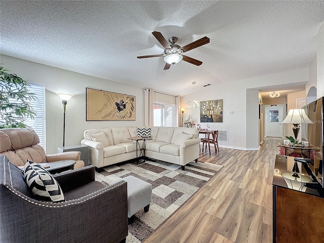 living room with a textured ceiling, wood-type flooring, and ceiling fan