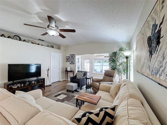 living room featuring lofted ceiling, a textured ceiling, wood-type flooring, and ceiling fan