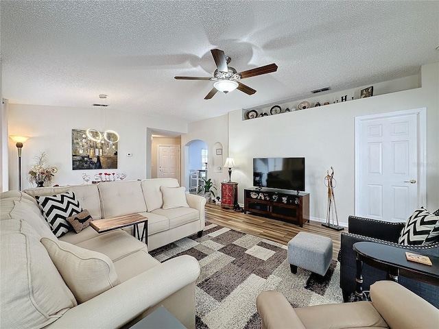 living room featuring a textured ceiling, hardwood / wood-style flooring, and ceiling fan