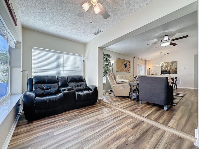 living room with a wealth of natural light, hardwood / wood-style flooring, and ceiling fan