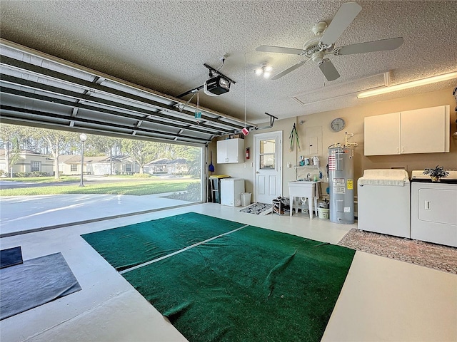 garage with a garage door opener, washer and clothes dryer, electric water heater, and ceiling fan