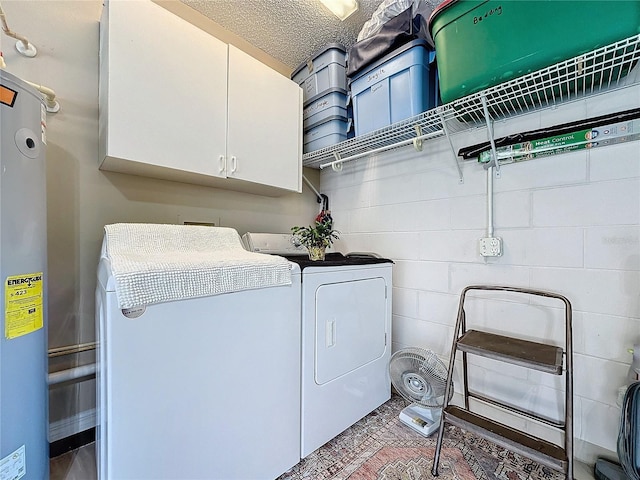 laundry area featuring water heater, independent washer and dryer, a textured ceiling, and cabinets