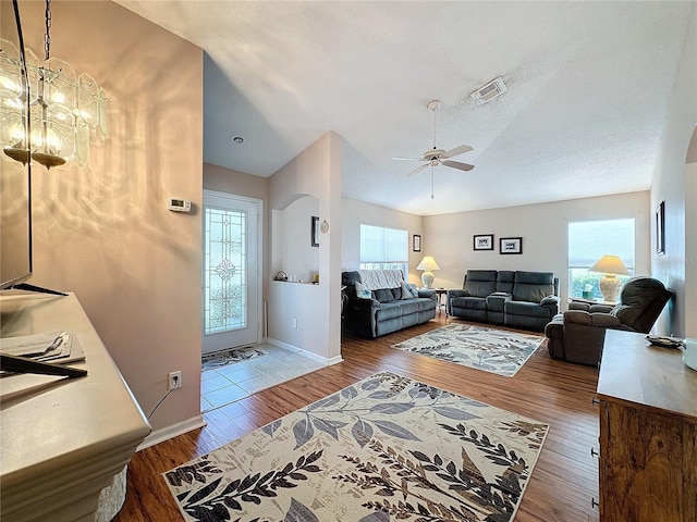 living room featuring a textured ceiling, hardwood / wood-style flooring, and ceiling fan