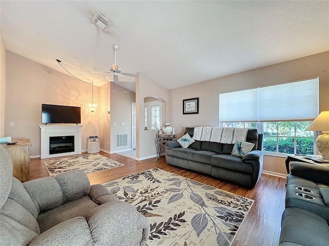 living room featuring wood-type flooring, vaulted ceiling, and ceiling fan