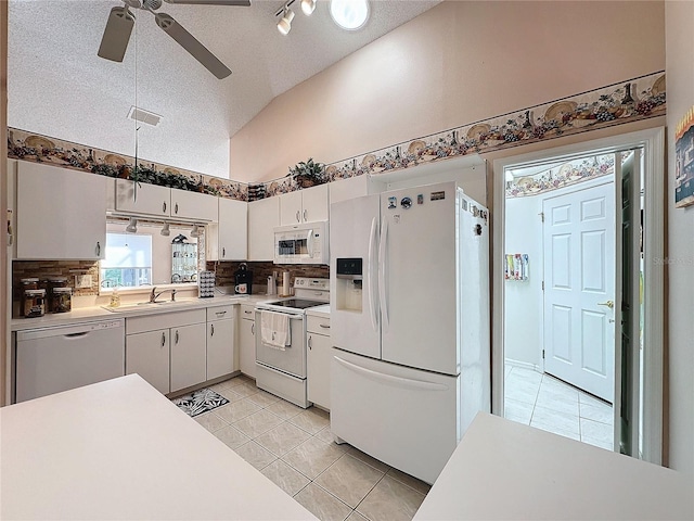 kitchen with white appliances, a textured ceiling, sink, and white cabinets