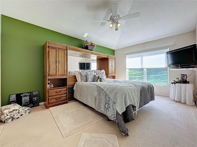 bedroom with a textured ceiling, light colored carpet, and ceiling fan