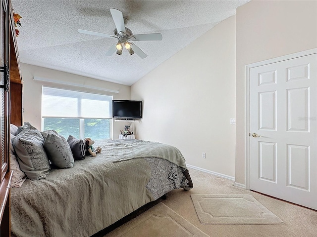 bedroom with carpet floors, a textured ceiling, vaulted ceiling, and ceiling fan