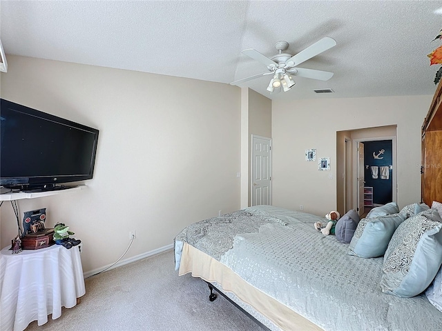 bedroom with ceiling fan, a textured ceiling, carpet, and lofted ceiling