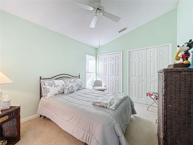 bedroom featuring ceiling fan, light carpet, a textured ceiling, and vaulted ceiling