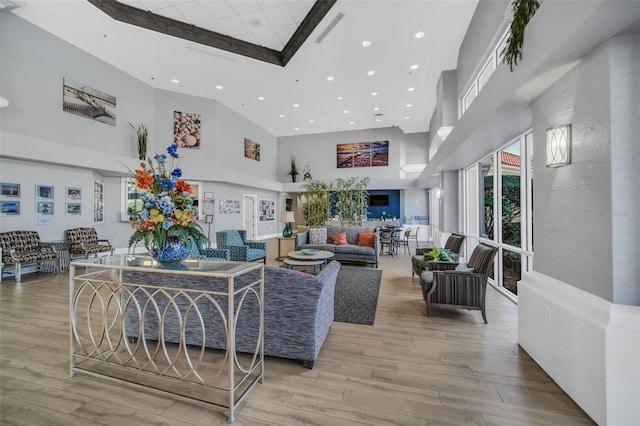 living room with light hardwood / wood-style flooring and high vaulted ceiling