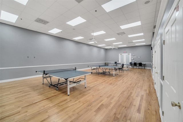 recreation room featuring a drop ceiling and light wood-type flooring