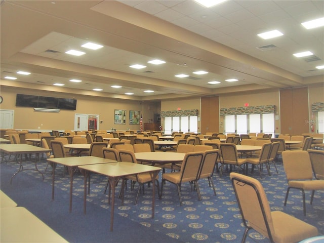 carpeted dining area with a paneled ceiling