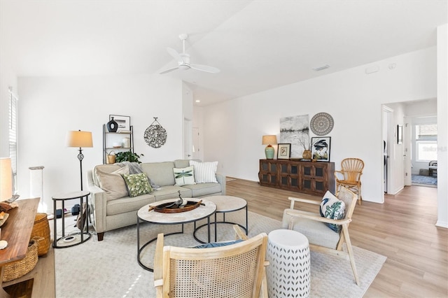 living room featuring light hardwood / wood-style floors, lofted ceiling, and ceiling fan