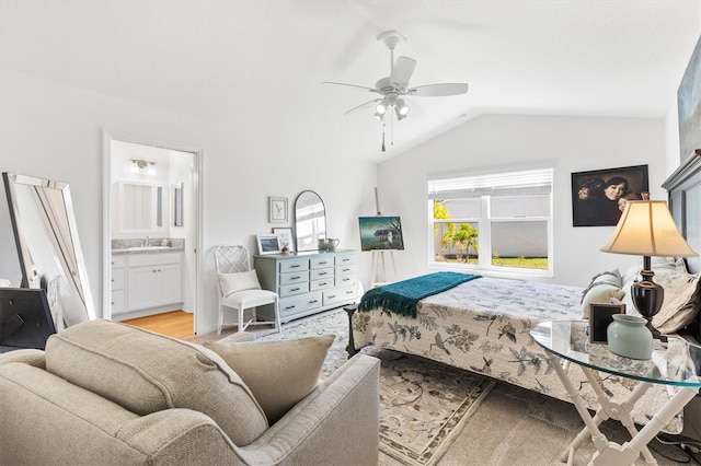 bedroom with sink, ensuite bath, ceiling fan, light hardwood / wood-style floors, and vaulted ceiling