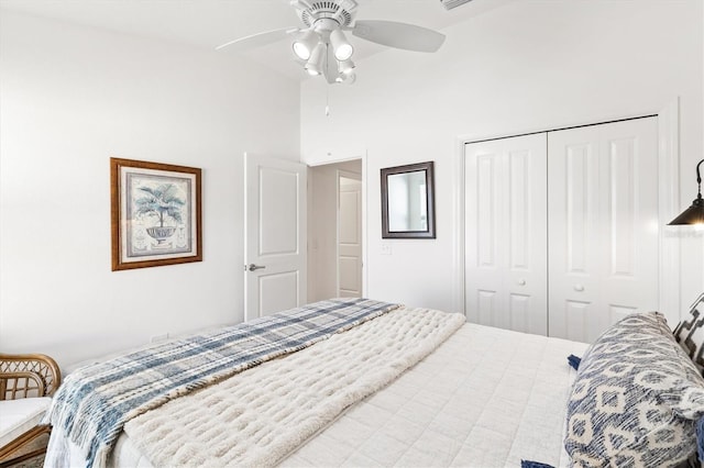 bedroom featuring a closet, ceiling fan, and a high ceiling