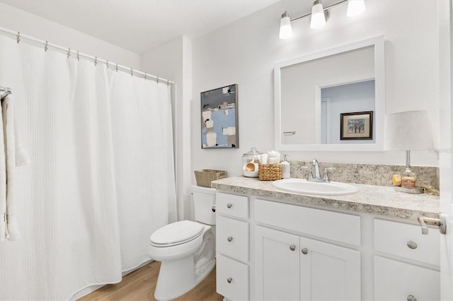 bathroom with vanity, wood-type flooring, and toilet