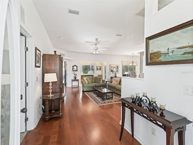 living room with hardwood / wood-style flooring and ceiling fan with notable chandelier