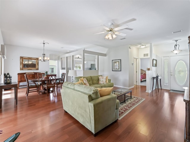 living room with dark hardwood / wood-style floors and ceiling fan with notable chandelier