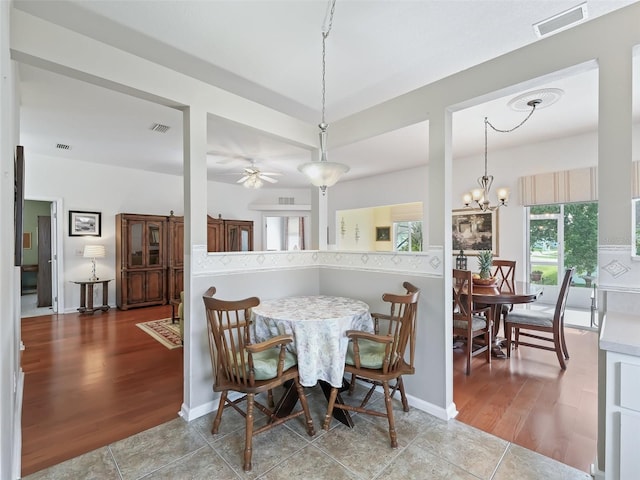 dining room featuring hardwood / wood-style flooring and ceiling fan with notable chandelier