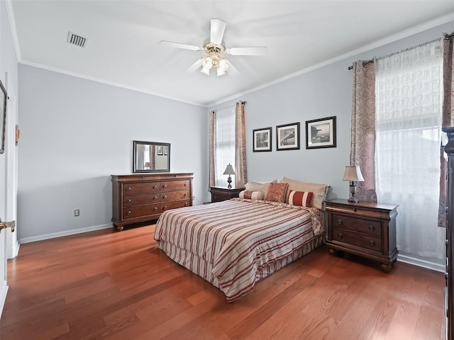 bedroom with hardwood / wood-style floors, crown molding, and ceiling fan