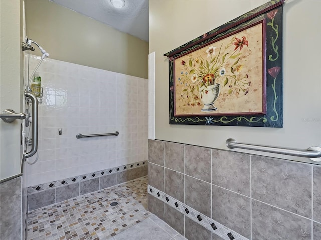 bathroom featuring tile patterned flooring and tiled shower