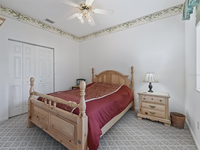 bedroom featuring a closet, light colored carpet, and ceiling fan