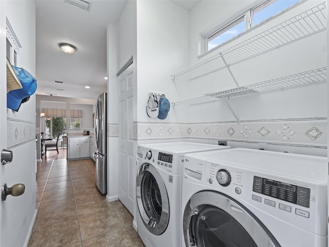 clothes washing area featuring washing machine and dryer and tile patterned flooring