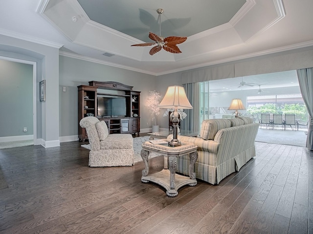 living room with crown molding, ceiling fan, a tray ceiling, and dark hardwood / wood-style flooring