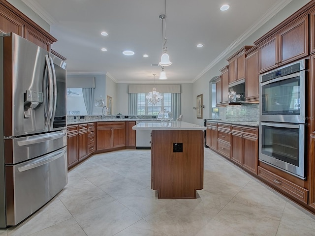 kitchen featuring appliances with stainless steel finishes, a center island, kitchen peninsula, hanging light fixtures, and crown molding