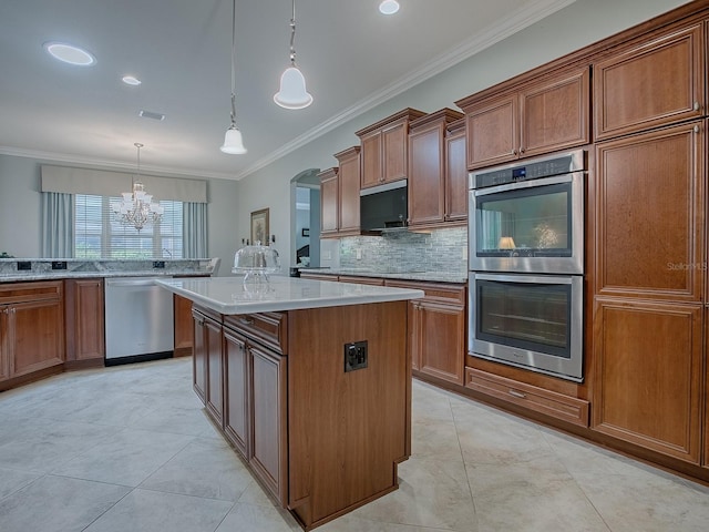 kitchen with stainless steel appliances, backsplash, ornamental molding, a center island, and decorative light fixtures