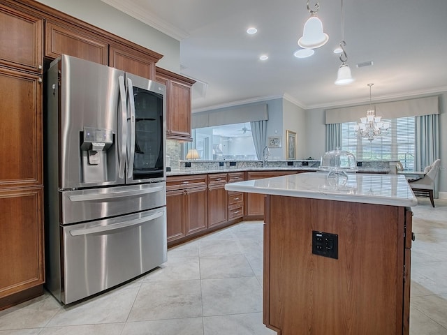 kitchen featuring ornamental molding, stainless steel refrigerator with ice dispenser, a chandelier, and a kitchen island