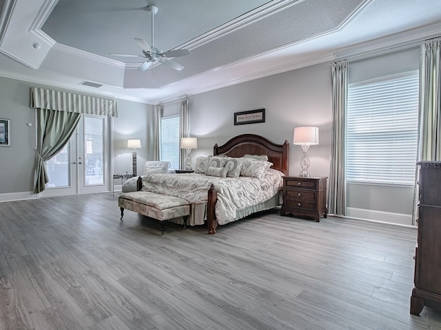 bedroom with multiple windows, access to exterior, light wood-type flooring, and ceiling fan