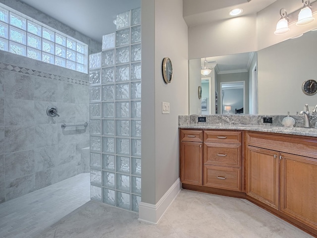 bathroom featuring vanity, crown molding, tile patterned floors, and tiled shower