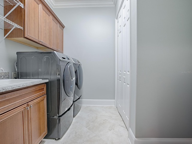 laundry room with washer and dryer, crown molding, and cabinets