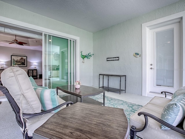 carpeted living room featuring a textured ceiling and ceiling fan