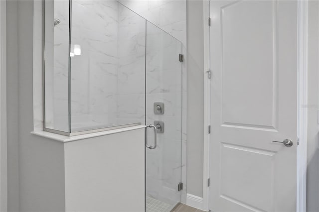 bathroom with a shower with door