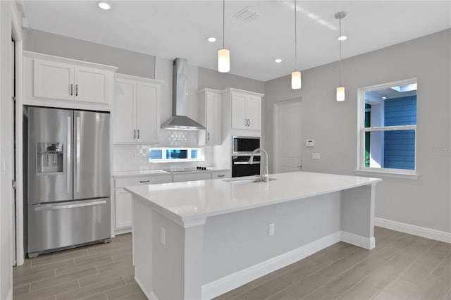 kitchen with white cabinets, stainless steel appliances, wall chimney exhaust hood, and sink